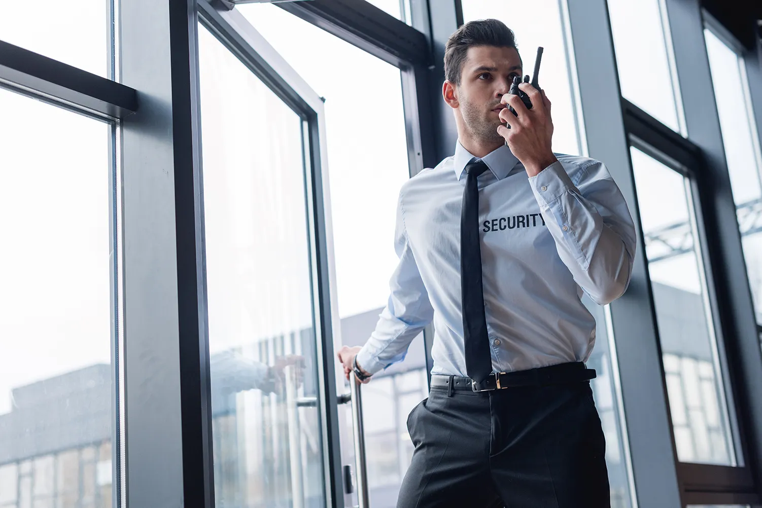 Hübscher Wächter im Anzug, der über Walkie-Talkie spricht