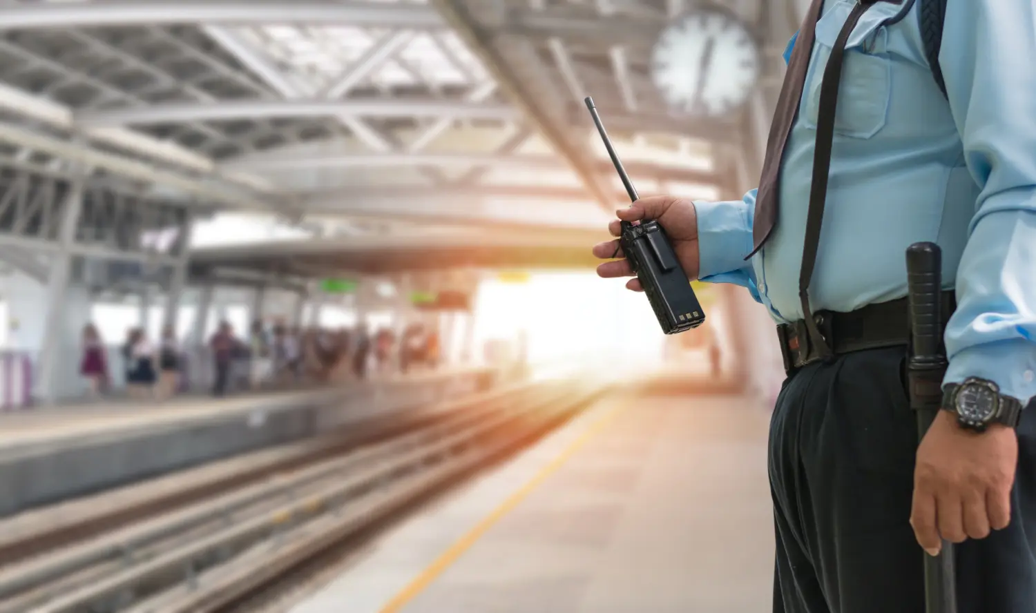 Professioneller Sicherheitsbeamter hält CB-Walkie-Talkie-Radio im elektrischen Bahnhof